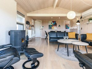 Ein modernes Wohnzimmer mit Kamin, Ledermöbeln und einem Essbereich.