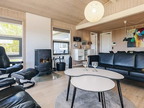 Un salon moderne avec une cheminée, des meubles en cuir et un coin repas.