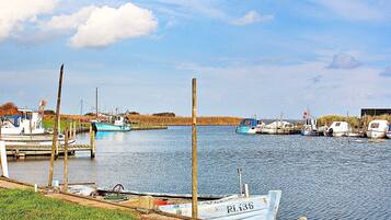A calm water body with boats docked at wooden piers.