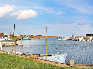 A calm water body with boats docked at wooden piers. - 6 Person Holiday Home in Hvide Sande (Hvide Sande)