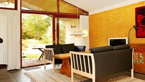 A modern living room with a sofa, a wooden table, and a television. - 4 Star Holiday Home in Nexo (Nexø)