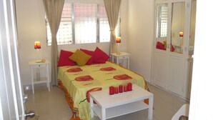 Ein Schlafzimmer mit einem Bett, zwei Nachttischen, einem Spiegel und einem Kleiderschrank.