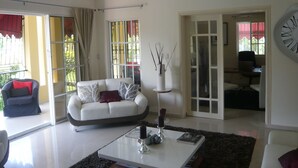 Ein modernes Wohnzimmer mit einem weißen Sofa, einem Couchtisch und einem Deckenventilator.