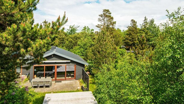 A cabin with a patio, surrounded by dense forest. - 5 Person Holiday Home in Hemmet (Hemmet)