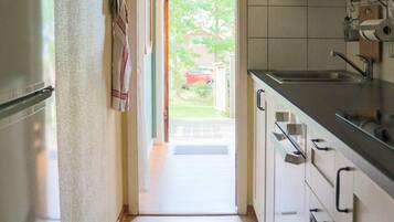 A kitchen with a refrigerator, cabinets, and a sink.