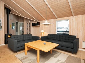 A cozy living room with two sofas, a wooden coffee table, and a fireplace. - Quaint Holiday Home in LÃ¸kken near Beach (Lokken)