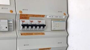 A control panel with various switches and labels, including 'ALARM' and 'VAN HOUTEN.'