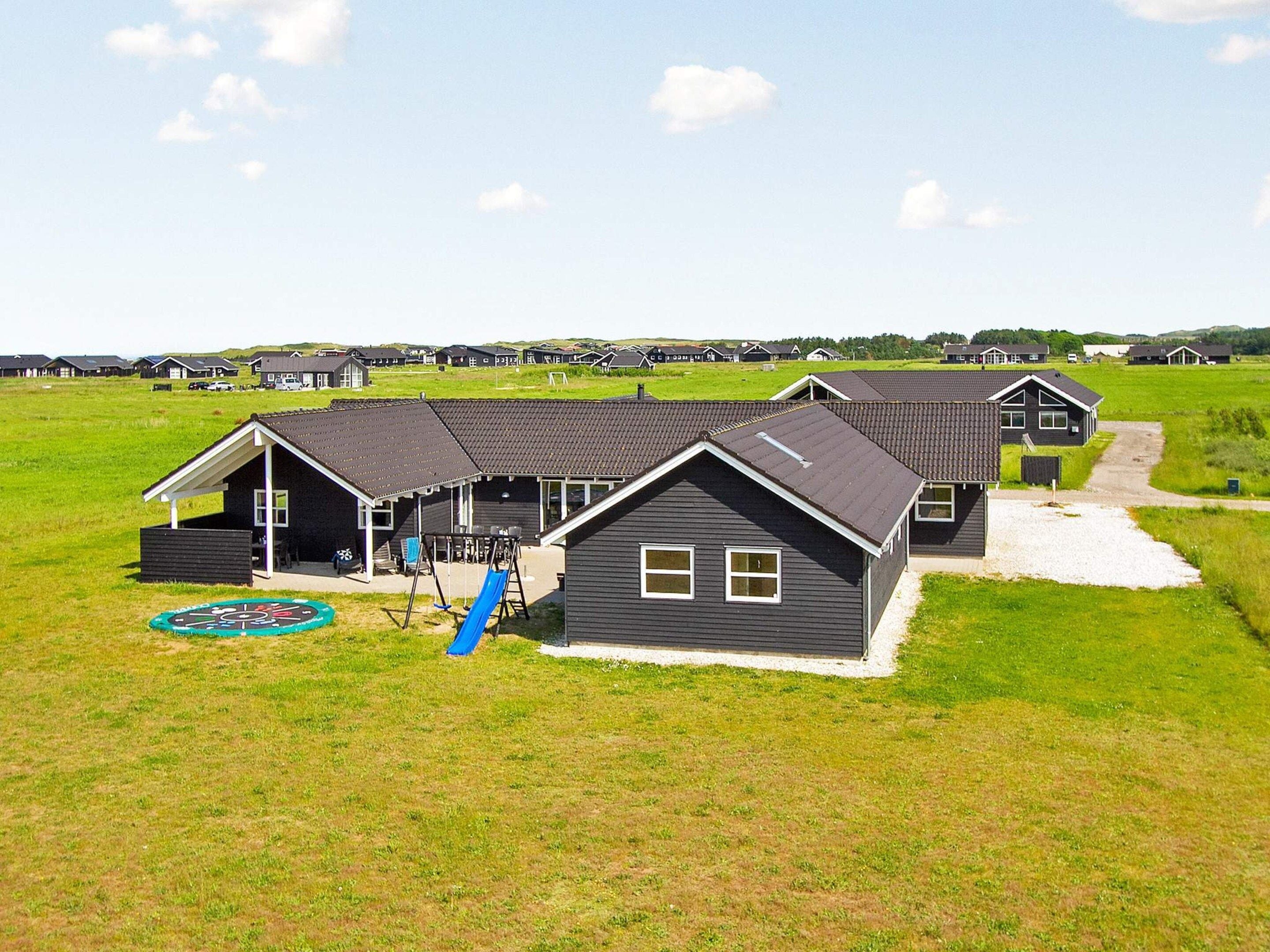 A residential area with multiple houses, a playground, and a green field.