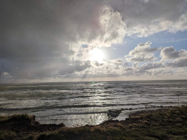 A coastal landscape with a body of water, rocky shoreline, and a cloudy sky. - 5 Star Holiday Home in Lokken (Lokken)