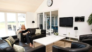 Una sala de estar moderna con un sofá, una mesa de centro y una televisión.