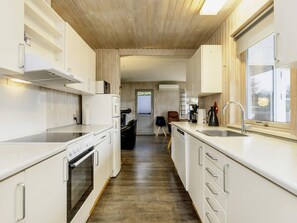 A modern kitchen with white cabinetry, a built-in oven, and a sink. - Enticing Holiday Home in Falster near Sea (Vaeggerlose)