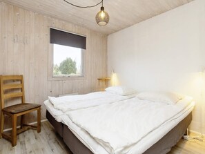 A bedroom with a bed, a chair, a window, and a lamp. - Enticing Holiday Home in Falster near Sea (Vaeggerlose)