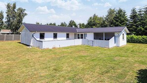 A single-story building with a sloped roof, a covered porch, and a fenced yard. - Enticing Holiday Home in Falster near Sea (Vaeggerlose)