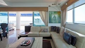Sala de estar moderna com sofá, mesa de centro e vista para a varanda.