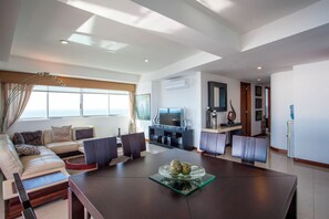 Un salon moderne avec un canapé, une table basse en verre et un téléviseur.