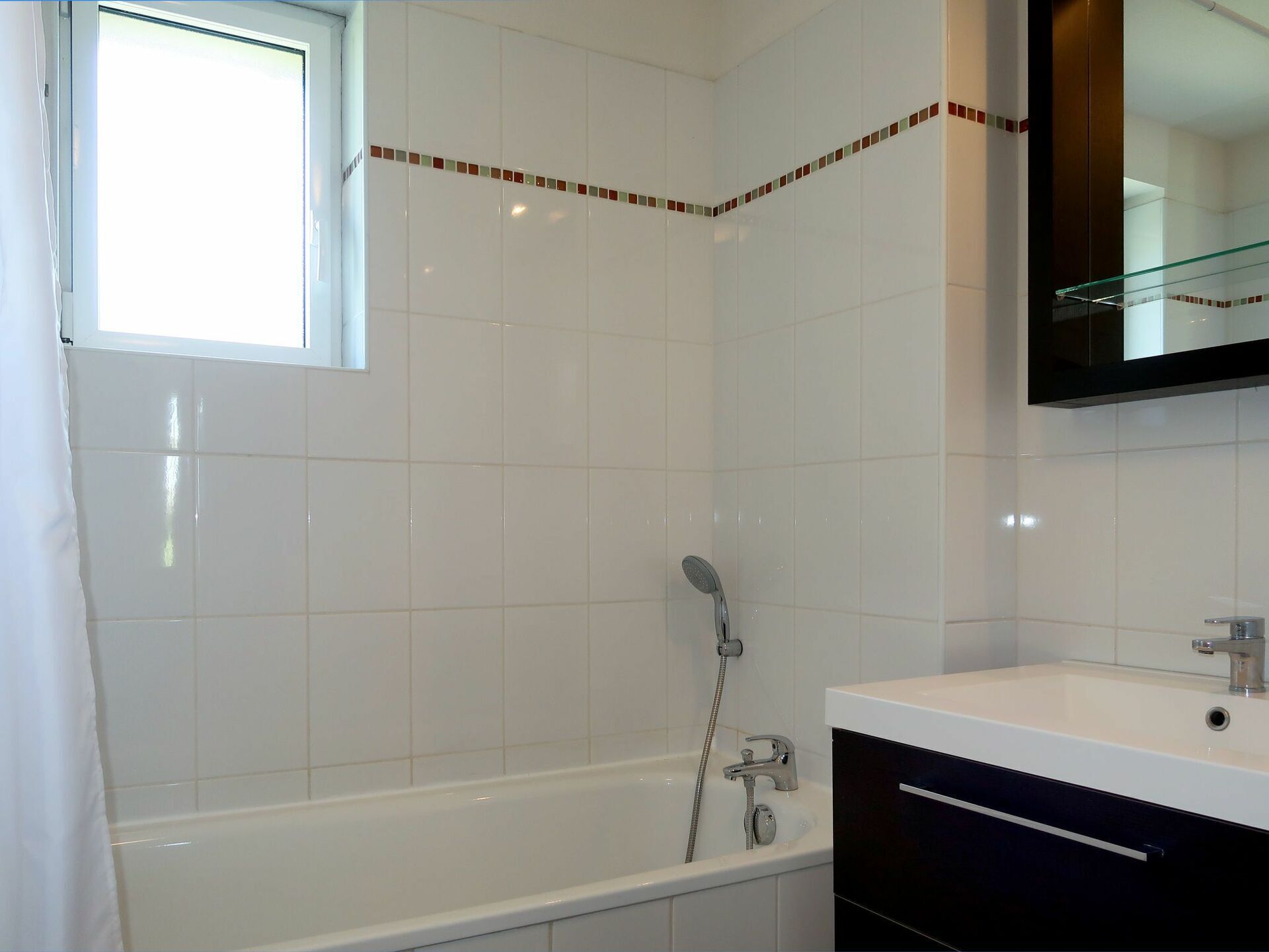 Une salle de bain avec une baignoire, une douche, un lavabo et un miroir.
