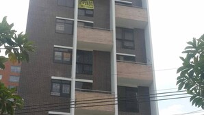 Um edifício alto, com várias janelas e varandas.