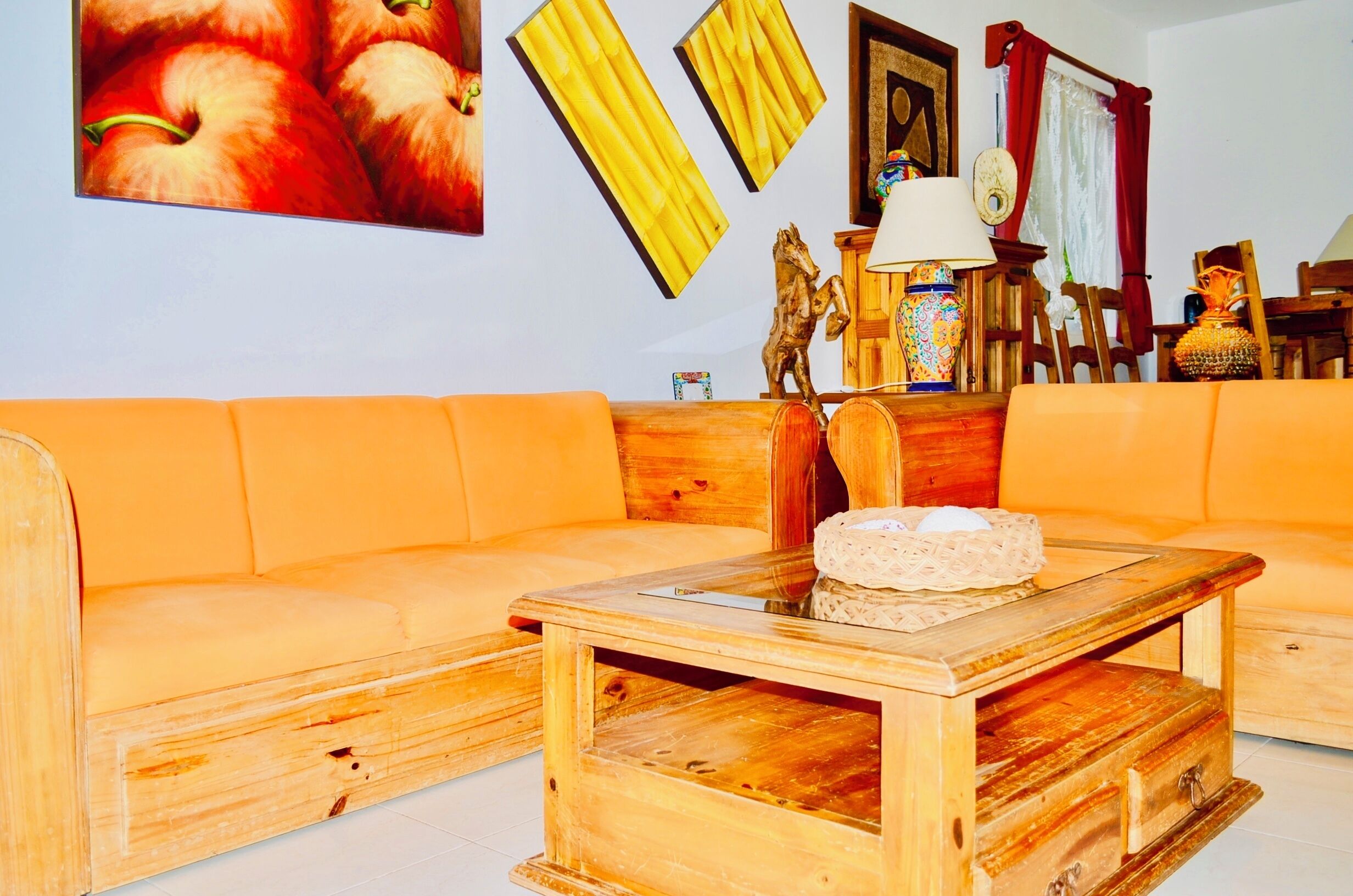 A cozy living room with a wooden sofa, a small wooden coffee table, and a wall adorned with framed artwork and decorative items.