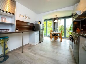 Mikrobølgeovn, ovn, oppvaskmaskin og høy barnestol