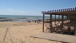Un restaurante frente a la playa con terraza y vistas al océano.