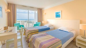 A hotel room with two beds, a desk, and a balcony with chairs. - Beautiful apartment for 5 people with pool, WIFI, TV, terrace and pets allowed (Château-d'olonne)