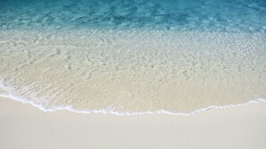 Ein Strand mit klarem Wasser und sandigem Ufer.