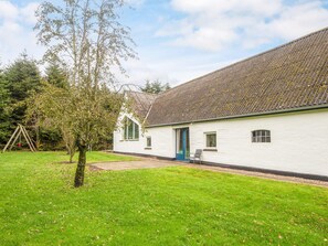A white building with a sloped roof and a door with a blue frame.