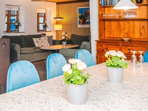 A living room with a sofa, a coffee table, and a dining area with chairs and a table. - 14 Person Holiday Home in Orsted (Ørsted)