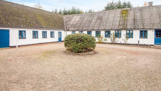 A traditional building with a gravel courtyard, white walls, and blue doors. - 14 Person Holiday Home in Orsted (Ørsted)