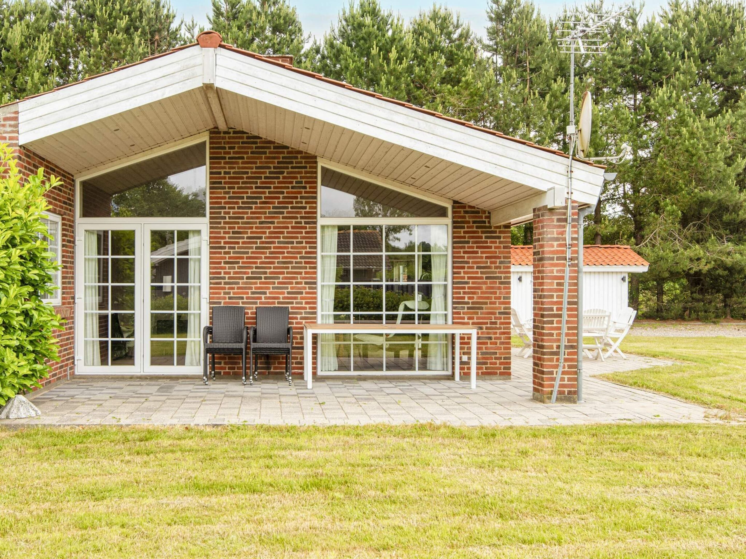 A two-story house with a covered patio, large windows, and a brick exterior.