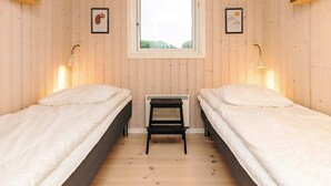 A room with two beds, a window, and a radiator. - 5 Star Holiday Home in Faaborg (Faaborg)