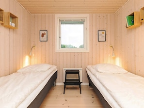 Een kamer met twee bedden, een raam en een radiator.