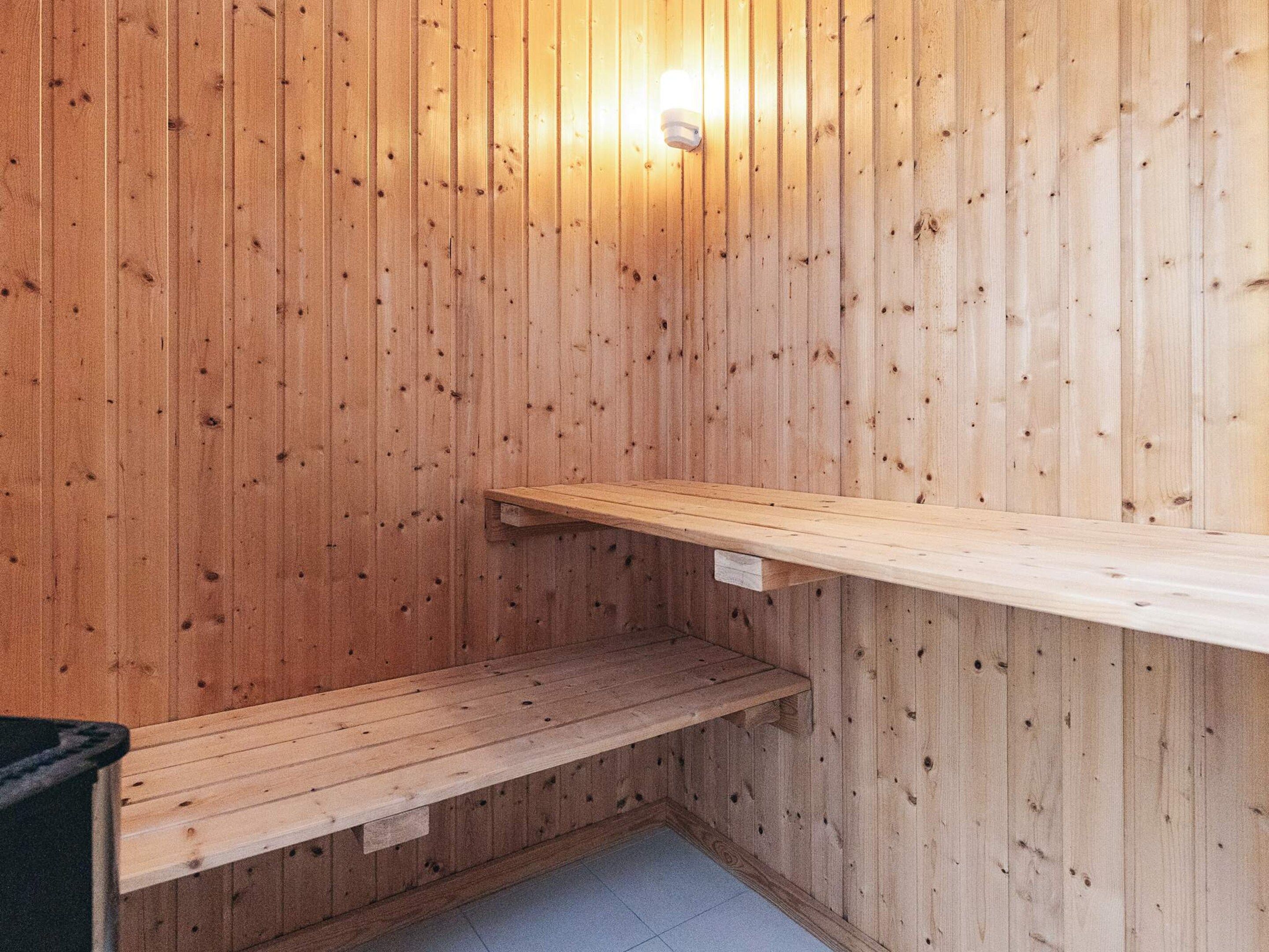 A wooden sauna with a bench and a shelf.