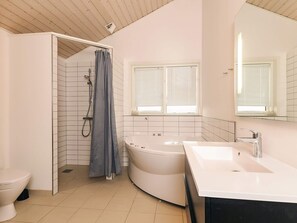 A modern bathroom with a shower, toilet, bathtub, and sink.