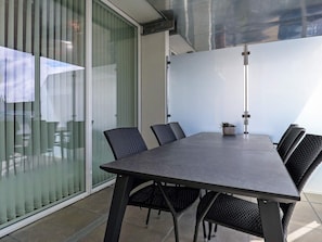 A conference room with a glass partition, black woven chairs, a dark table, and a potted plant. - Spacious Apartment in RingkÃ¸bing near Sea (Ringkobing)