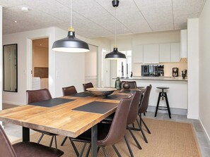 A modern kitchen with white cabinets, a black countertop, and a microwave.