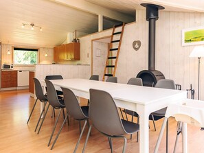 A modern kitchen with wooden cabinets, a white countertop, and a black stove. - 4 Star Holiday Home in Vaeggerlose (Vaeggerlose)