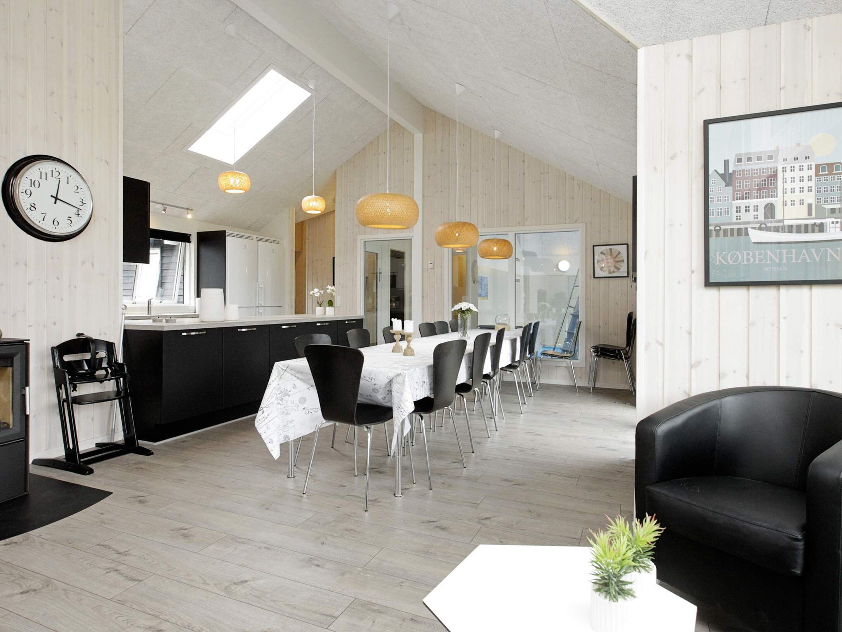Un intérieur moderne comprenant un coin repas, une cuisine et un espace salon.