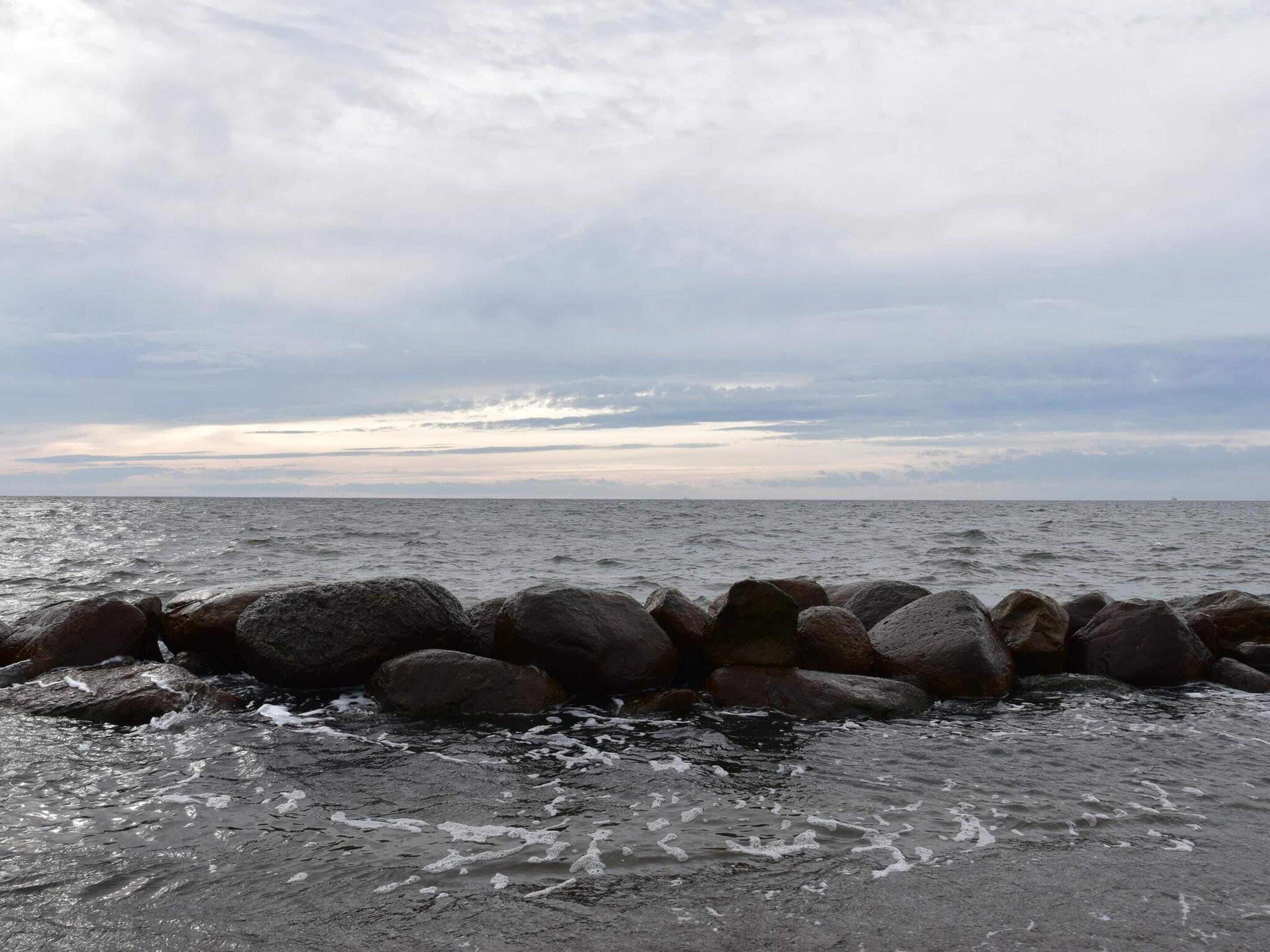 A rocky shoreline with waves crashing against the rocks.
