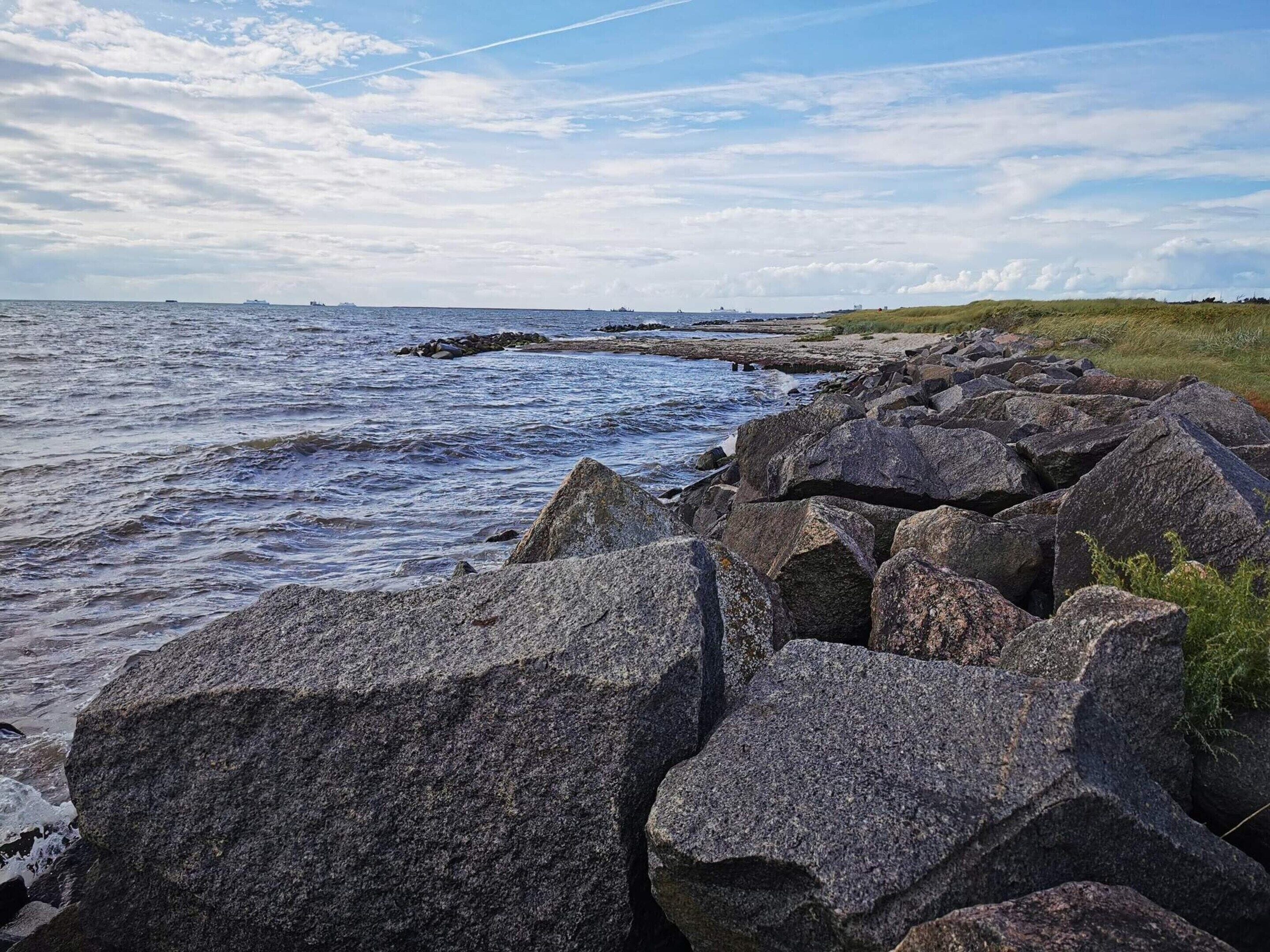 A rocky shoreline with waves crashing against the rocks.
