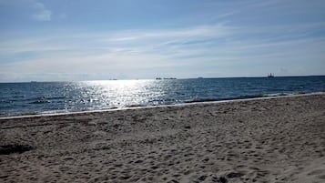 A sandy beach with a clear sky and calm sea.
