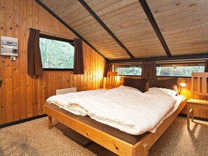 A wooden cabin bedroom with a single bed, two windows, and a nightstand. - 6 Person Holiday Home in Rodby (Rodby)
