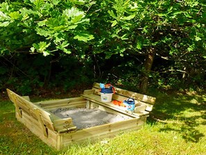 A wooden structure with a bench and a bucket, surrounded by greenery. - 5 Star Holiday Home in Vaeggerlose (Vaeggerlose)