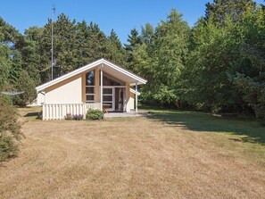 A single-story building with a sloped roof, a fenced yard, and a satellite dish. - 5 Star Holiday Home in Vaeggerlose (Vaeggerlose)