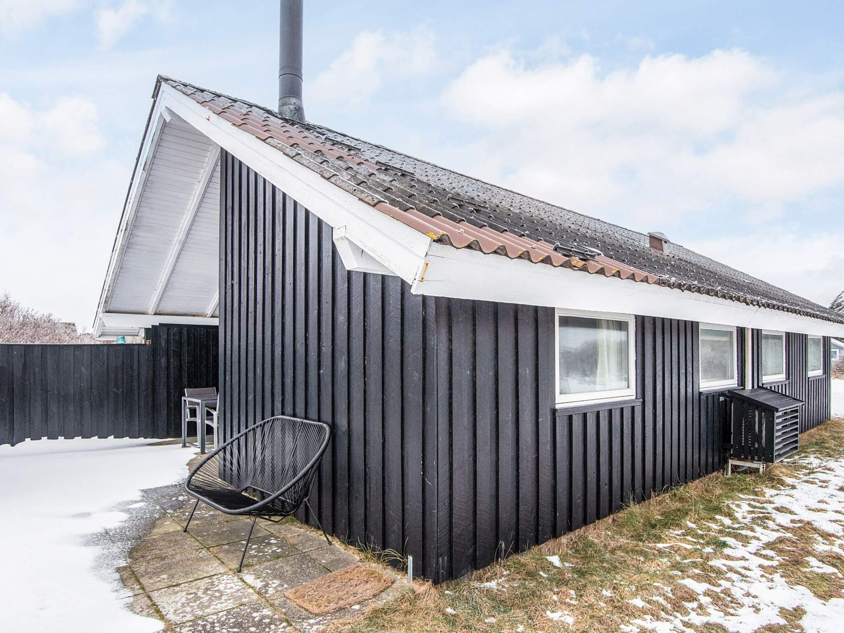 A single-story building with a sloped roof, a chimney, and a window.
