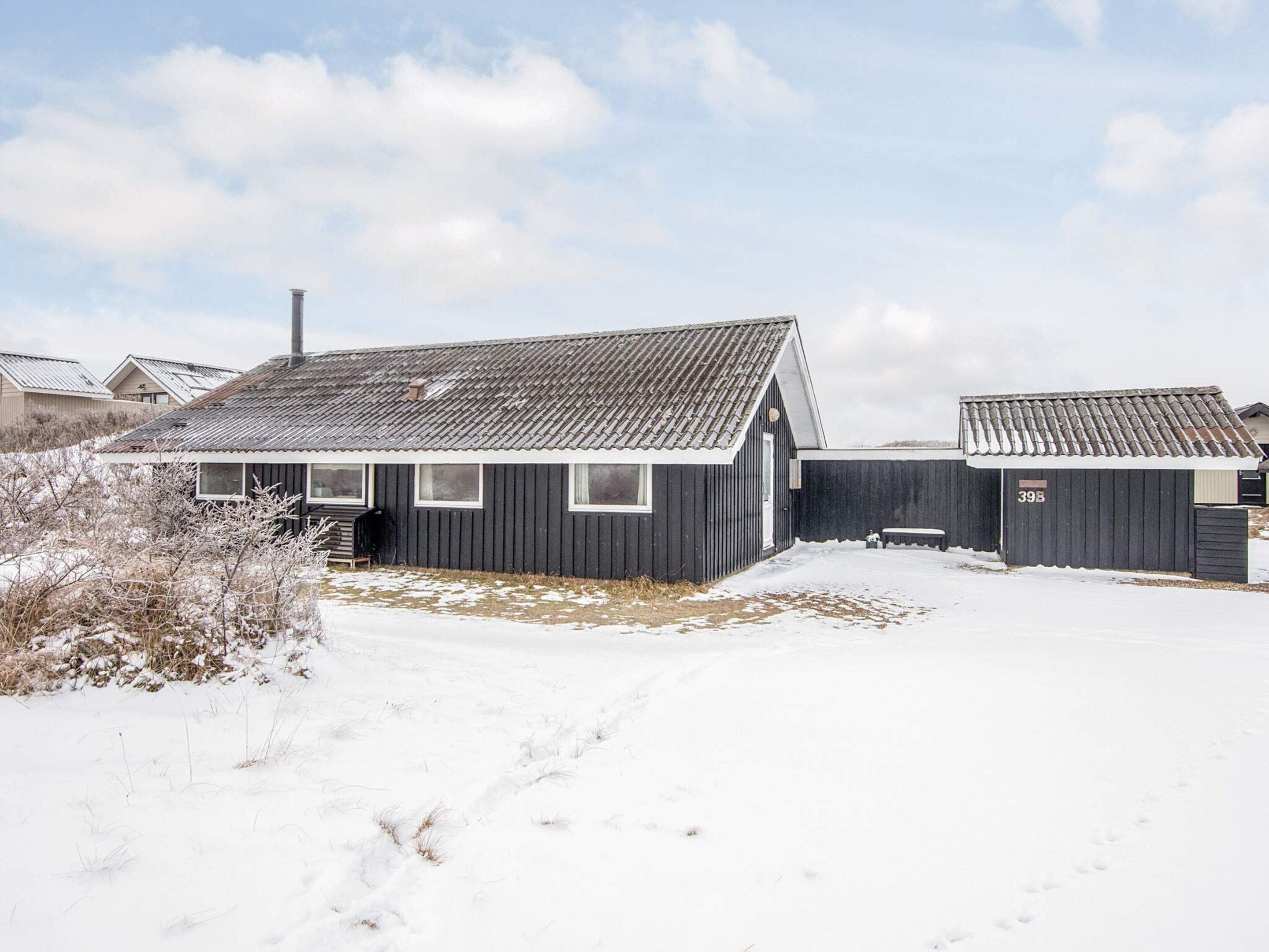 A single-story building with a sloped roof, a chimney, and a small porch area.