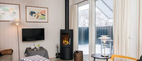 A cozy living room with a fireplace, a television, and a comfortable seating area.