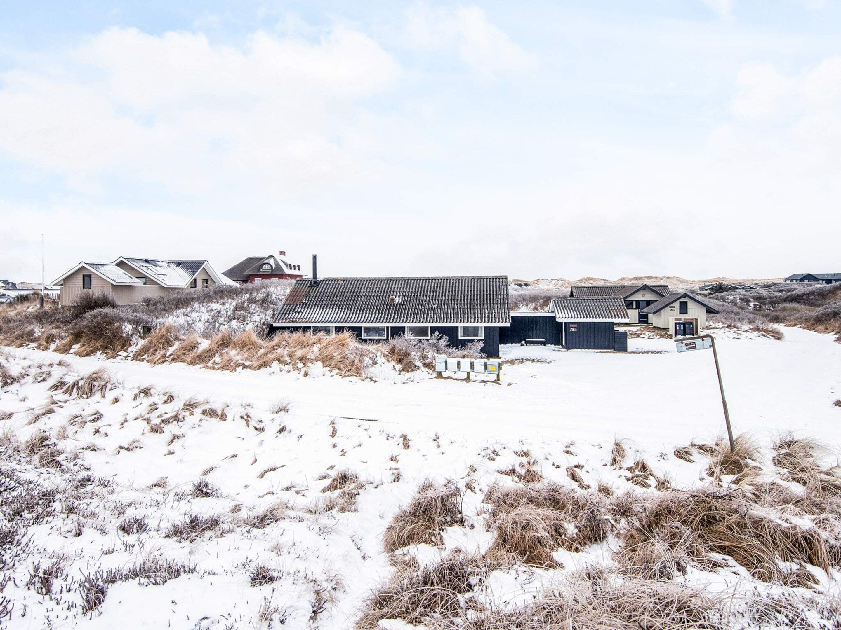 Varias cabañas con un paisaje nevado y cielo despejado.