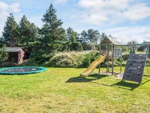 A playground with a slide, climbing wall, and a small wooden structure. - Chic Holiday Home in Jutland near Sea (Blavand)
