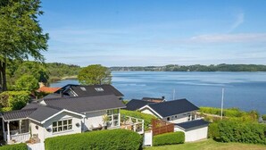 A residential area with houses near a large body of water, surrounded by greenery. - 4 Star Holiday Home in Borkop (Borkop)